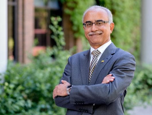 a portrait of chancellor dutta with his arms crossed