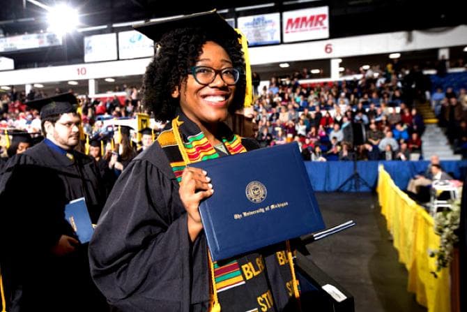 a portrait of Jaslyn Morris holding her diploma